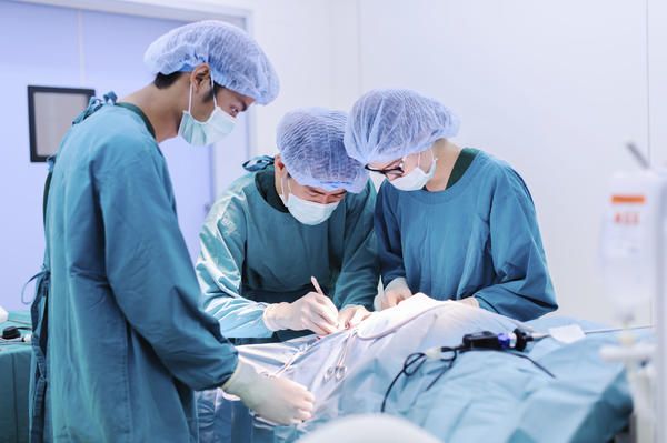 Surgical oncologist discussing cancer treatment plan with medical team in a modern hospital setting
